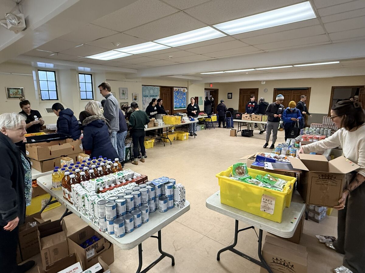 Tables of fresh food, groceries, and water laid out for neighbors on a Good Neighbors pantry day